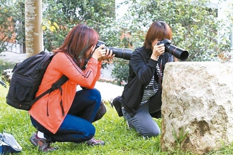 蔡媽媽（左）和攝影班同學，到苗栗客家大院拍桐花，拿相機的姿勢愈來愈專業。 圖／蔡...