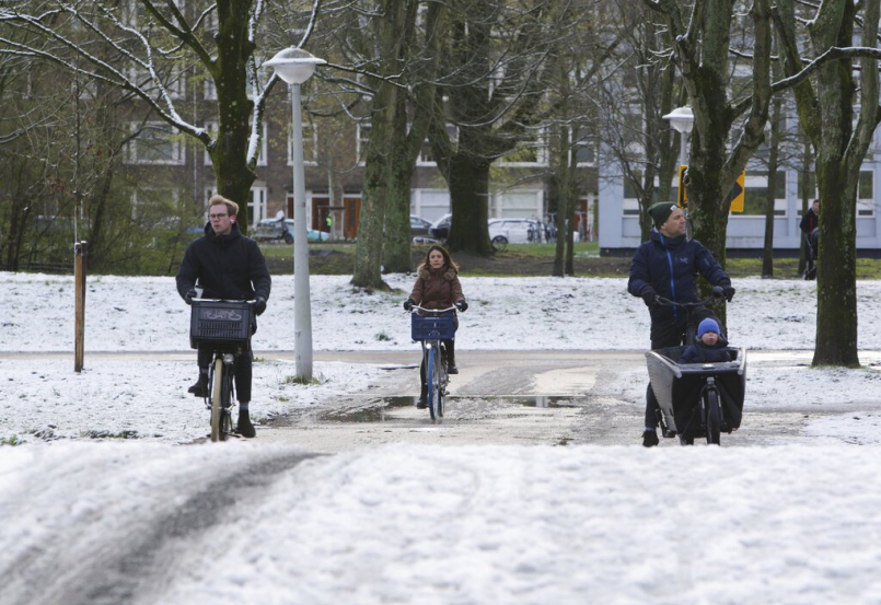 荷蘭首都阿姆斯特丹的居民在雪地中騎自行車與步行。 圖／美聯社