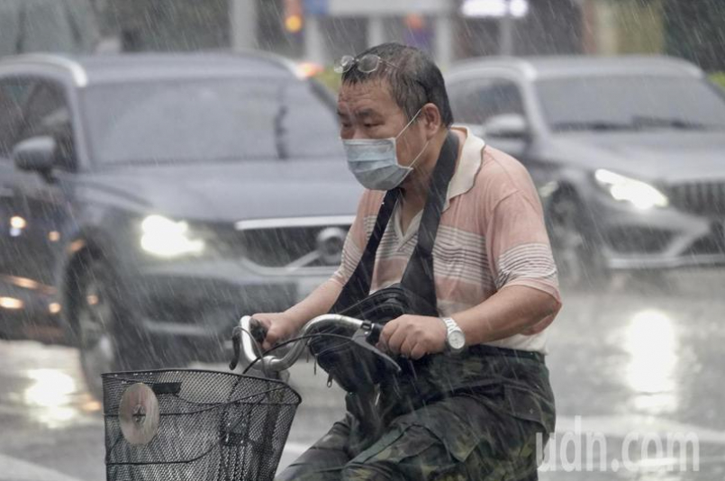 中央流行疫情指揮中心今天宣布，即日起放寬配戴口罩的防疫措施，騎乘單車、機車可以免戴口罩，下午政策宣布後，台北市正逢下大雨，許多機車、腳踏車騎士仍在雨中戴口罩騎車十分不方便。記者林俊良／攝影