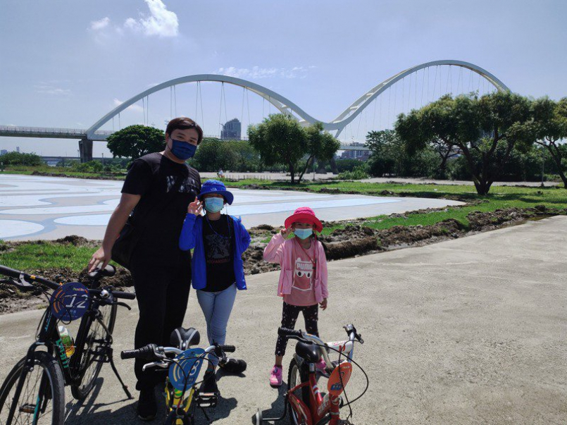 父親與小孩們到河濱公園騎自行車遊玩。圖／新北市水利局提供