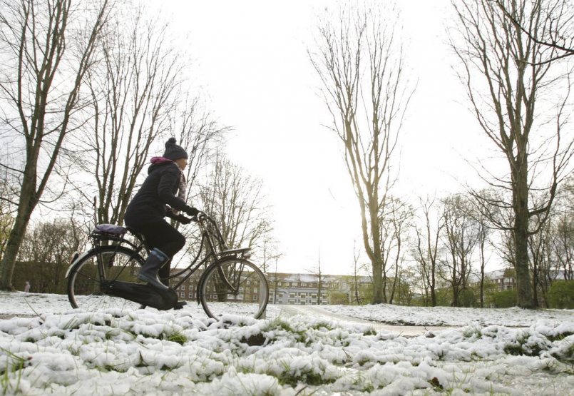 荷蘭首都阿姆斯特丹的居民在雪地中騎自行車。 圖／美聯社
