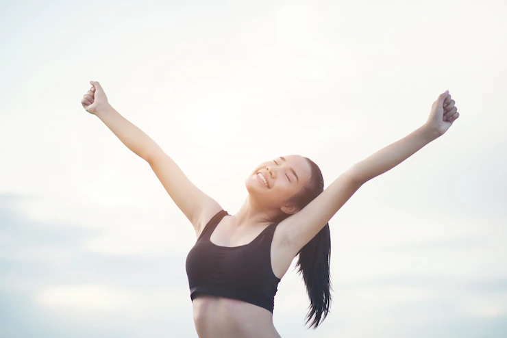 Happy smiling athletic woman with arms outstretched 