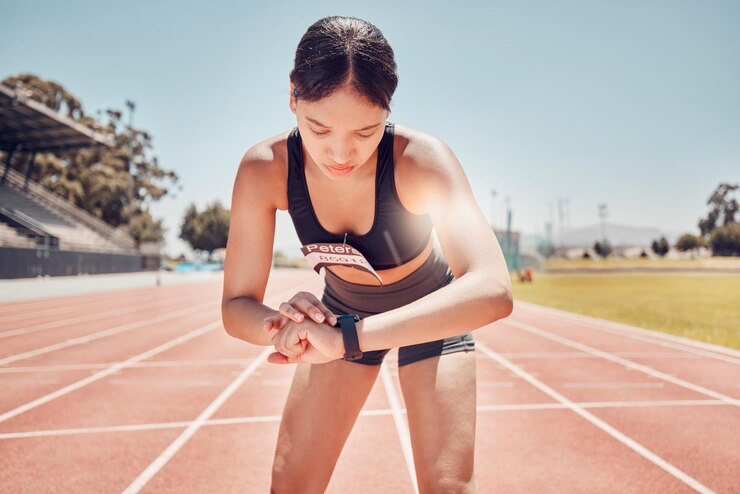Fitness smartwatch or woman runner checking digital app for training running marathon or workout in sports stadium track Health or black woman with time monitor for wellness or marathon exercise